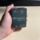 Černý kovový box s nápisy v zelené barvě. Uprostřed je logo a název značky bespeco a pod ním model DBX-10. Na horní části jsou nápisy link output a b…