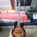 Kytara s polodupatým tělem v barvě sunburst a hnědým hnedkem. Na hlavě je viditelné logo značky Gretsch. Nástroj má dva snímače, dvě kontrolní knoflí…