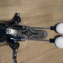 Černý bicí pedál s dvěma beatery zakončenými bílými plstěnými hlavicemi. Na šlapáku je viditelné logo MAPEX v oválném rámečku. Nástroj vykazuje mírné…