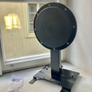 Černý cýrní pad značky Gibraltar s nápisem PRACTICE PAD, umístěný na černé kovové základně. Pad je kruhový a upevněn šesti šrouby k vnějšímu rámu. Ve…