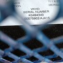 Detailní záběr na bílý štítek s černým textem, který je vidět skrz modrou plastovou síťku. Na štítku jsou uvedeny nápisy VKHD, SERIAL NUMBER K0494343…
