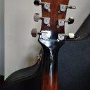 Fotografie zachicuje hlavu hnědé kytary s chromovanými ladičkami. Na každém z šesti ladiček je vidět logo s písmenem „E“ a nápisem „Epiphone“. Povrch…