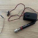 Černý kabel s červenými vodiči a stříbrným opletením, který končí v konektoru s nápisy „Belcat“ a „AP-55 AP JACK“. Součástí je černý plastový box s t…