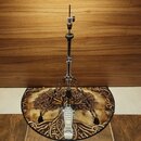 Kromě stojanu na mikrofon z chromovaného kovu je na fotografii vidět kulatý podklad s motivem stromu. Stojan má tříramennou základnu s černými gumový…