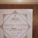Detail štítku uvnitř akustické kytary. Štítek obsahuje nápisy AMADA, CLASSIC GUITAR a MADE BY ČESKÁ MANUFAKTURA LUBY • CZECH REPUBLIC. Ručně dopsané…