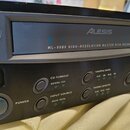 Černý digitální nahrávací zařízení s nápisem Alesis MASTERDISK ML-9600 HIGH-RESOLUTION MASTER DISK RECORDER. Na předním panelu jsou tlačítka POWER, O…