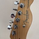 Zadní strana hlavy kytary z přírodního dřeva s chromovanými ladičkami. Je na ní vidět logo Fender, nápis MADE IN U.S.A. a označení "TELECASTER". Povr…