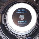 Fotografie zobrazuje zadní stranu černého reproduktoru. Na středovém magnetu je bílý štítek s modrým nápisem SM110/N, LOW FREQUENCY LOUDSPEAKER a log…