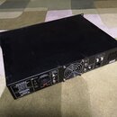 Černý rackový zesilovač s kovovým šasi. Na zadní straně jsou viditelné nápisy „Hartke“, „N382“ a „SPEAKER OUTPUT“. Zařízení obsahuje ventilátor, napá…