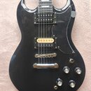 Černá elektrická kytara s dvěma humbuckery, z nichž jeden má zlatý kryt. Na těle jsou čtyři ovládací knofíky a přepínač tónu. Povrch laku vykazuje dr…