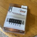 Balení šesti černých kobylkových sedlíček pro kytaru s přiloženými montážními šrouby. Na obalu jsou nápisy String SAVER, High Performance Saddles a G…