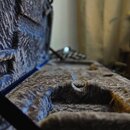 Fotografie zachicuje vnitřek otevřeného nástrojového pouzdra. Interiér je vyložen šedým, texturovaným plyšovým materiálem. Na povrchu jsou vidět znám…