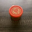 Červený plastový kelímek s víkem. Na horní části je nápis POPS' PRODUCTS, INC. HOUSTON TEXAS 77381 a logo s nápisem POPS' PLATING. Povrch víka vykazu…