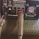 Černý elektronický přístroj s nápisem Two notes AUDIO ENGINEERING a logem. Na zadní straně jsou konektory s popisky THRU TS, ATT -20dB a INPUT 100W R…
