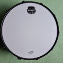 Bílý buben s černým obručem. Na horní části je černé logo MAPEX, ve spodní části nápis UX DRUM HEAD a text MADE BY REMO IN CHINA. Povrch blány je čis…