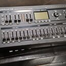 Černý polyfonní syntetizátor s nápisem DeepMind 12 ANALOG 12-VOICE POLYPHONIC SYNTHESIZER. Na předním panelu jsou vidět knofíky, tlačítka a displej s…