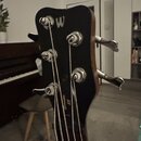 Záběr na hlavu basové kytary v černé barvě s kovovými ladičkami. Na horní části je bílé písmeno W a na hřideli nápis Concerto S5. Povrch je v dobrém…