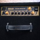 Kombinovaný basový zesilovač s černým potahem a béžovým ovládacím panelem. Na panelu je nápis Mark bass Combo Head II a řada ovládacích knoflíků s oz…