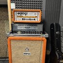 Sada kytarového zesilovače složená z oranžové hlavy s nápisem ORANGE ROCKERVERB, stříbrné hlavy MESA BOOGIE Dual Rectifier a oranžového reproduktorov…