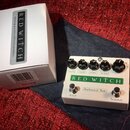 Bílý kytarový efekt s nápisem RED WITCH a Pentavocal Trem. Na horní straně jsou čtyři černé otočné ovířky s popisy Velocity, Depth, Volume a Bottom.…