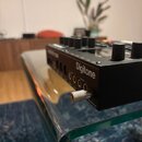 Černý digitální syntetizátor s nápisem Digitone. Na zadní straně jsou vidět čtyři konektory Output a jeden zapojený kabel v portu Headphones. Zařízen…