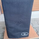 Černý textilní kryt na hudební zesilovač nebo reproduktor. V dolní části je bílé oválné logo s nápisem Ampeg Bass. Kryt stojí na dřevěné desce umístě…