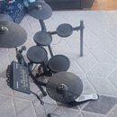 Elektronická bicí souprava s černými pady a činely na černém kovovém rámu. Na ovládacím modulu je vidět nápis CTX a logo YAMAHA. Souprava obsahuje ně…