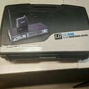 Černý plastový kufr s rukojetí, na kterém je nalepená produktová fotografie a text. Na nálepse je zobrazen bezdrátový systém s nápisem LD SYSTEMS ME1…