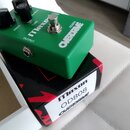 Zelený kytarový efekt v kovovém šasi s nápisy MAXON, OD808 a OVERDRINE. Na horní straně jsou tři černé ovládací knoflíky s popisky DRIVE, TONE a BALA…