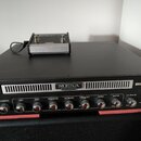 Černý basový zesilovač s nápisy MESA ENGINEERING a BIG-BLOCK 750. Na předním panelu jsou ovládací prvky Gain, Bass, Passive-Mid, Active-Mid, Frequenc…