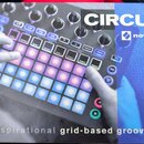 Fotografie zobrazuje produkt Novation Circuit, který je popsán jako „The inspirational grid-based groove box“. Na přístroji jsou vidět podsvícené čtv…