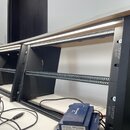 Dvě černé rackové police značky TIPTOP audio s integrovaným LED osvětlením v horní části. Konstrukce obsahuje perforované kovové lišty pro montáž zař…