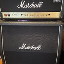 Kytarový zesilovač a kabinet značky Marshall v černé textuře s bílým lemováním. Horní hlava má zlatý panel s nápisem JCM 900 a 100W Hi Gain Dual Reve…