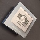 Fotografie zachycuje krabici s produktem Universal Audio. Na povrchu je zobrazen stříbrný zvukový rozhraní s nápisem apollo | twin a logem UNIVERSAL…