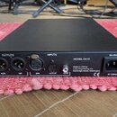 Černý rackový přístroj s nápisem MODEL DA10. Na zadním panelu jsou konektory OUTPUTS (right, left), INPUTS (aes, optical, spdif) a napájecí vstup s o…
