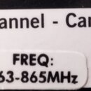 Detailní záběr na bílou nálepku s černým textem. Na ní je nápis Channel - Canal a pod ním menší nálepka s textem FREQ: 863-865MHz.