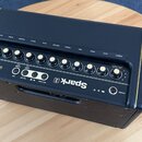 Černý kytarový kombo zesilovač s nápisem Spark 2. Na horním ovládacím panelu se nachází řada zlatých otočných knoflíků s popisky: GUITAR, MUSIC, REVE…