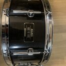 Černý buben s chromovaným obručováním a ladicími šrouby. Na korpusu je čtvercová štítková nálepka s nápisy MAPEX, MARS PRO SERIES a MADE IN KOREA. Po…