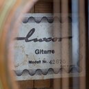 Detail vnitřní štítku kytary s nápisy luxor, Gitarre a Modell Nr. 42670. V pravém dolním rohu je uveden text MADE IN JAPAN. Štítek vykazuje známky op…