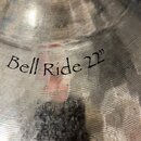 Detail kovového činchu s viditelným broušením povrchu. Na nástroji je černý nápis Bell Ride 22". Pod ním se nachází vyražené sériové číslo 08057673 a…