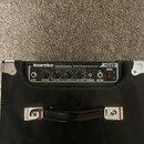 Černý basový kombo zesilovač značky Hartke s modelem HD25 a nápisem HYDRIVE SPEAKER TECHNOLOGY. Na ovládacím panelu jsou knofíky Volume, Bass, Mid a…