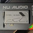 Šedá zvuková karta s kovovým krytem, položená na černém kartónovém obalu. Na krytu i na obalu je uveden nápis EVGA NU AUDIO a v pravém dolním rohu kr…