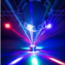 Fotografie zachycuje světelný efekt v tmavém prostoru. V centru je umístěno zařízení, které vyzařuje vějíře červených a modrých laserových paprsků do…