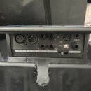 Zadní panel černého elektronického zařízení s nápisem TC-HELICON. Jsou zde viditelné konektory s popisky MIC IN, XLR OUT, TRS OUT (L a R), GUITAR THR…