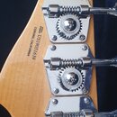 Zadní strana hlavy kytary z přírodního dřeva se čtyřmi chromovanými ladičkami. Na dřevě je černý nápis SERIAL NUMBER US19051639 CORONA, CALIFORNIA. N…