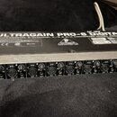 Stříbrný rackový přístroj s černým horním panelem. Na vrchu je bílý nápis ULTRAGAIN PRO-8 Digital a PROFESSIONAL 8-CHANNEL A/D & D/A CONVERTER MODEL…