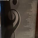 Fotografie zachycuje zadní obálku sbírky notového zápisu s názvem „50 greats for the Piano“. V horní části je bílé logo YAMAHA a nápis NOT FOR SALE.…