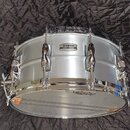 Stříbrný buben s chromovaným obručováním a ladicími šrouby. Na korpusu je vidět logo YAMAHA. Spodní blana nese nápis REMO. Nástroj vykazuje známky bě…