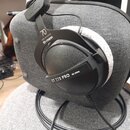 Černé uzavřené sluchátka s velkými náušníky a látkovým polstrováním. Na vnější straně náušníku je bílý nápis DT 770 PRO 80 OHM a na hlavovém oblouku…