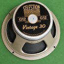 Kruhový reproduktor s béžovým kovovým rámem a černou membránou. Na černé středové krytce je zlatý nápis CELESTION LOUDSPEAKERS, dvakrát označení G12…